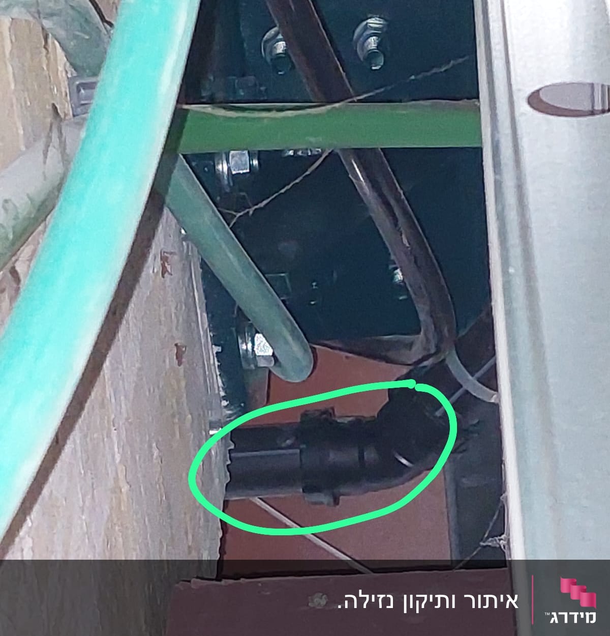 צינור שחור עם חיבורי מתכת בקיר